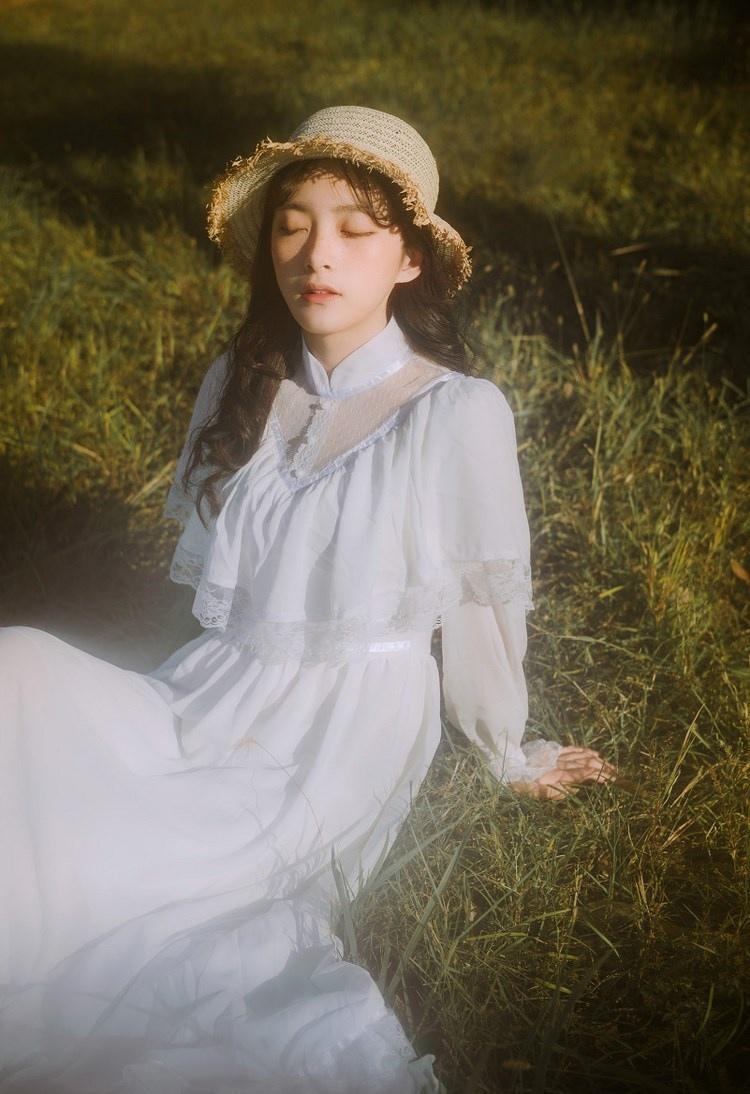 文藝美女潔白長(zhǎng)裙?jié)饷芫戆l(fā)手捧鮮花叢林寫(xiě)真圖片