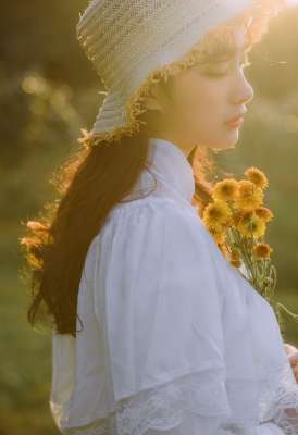 文藝美女潔白長裙?jié)饷芫戆l(fā)手捧鮮花叢林寫真圖片