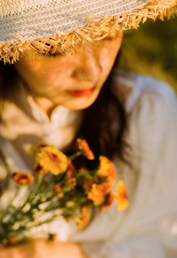 文藝美女潔白長(zhǎng)裙?jié)饷芫戆l(fā)手捧鮮花叢林寫(xiě)真圖片